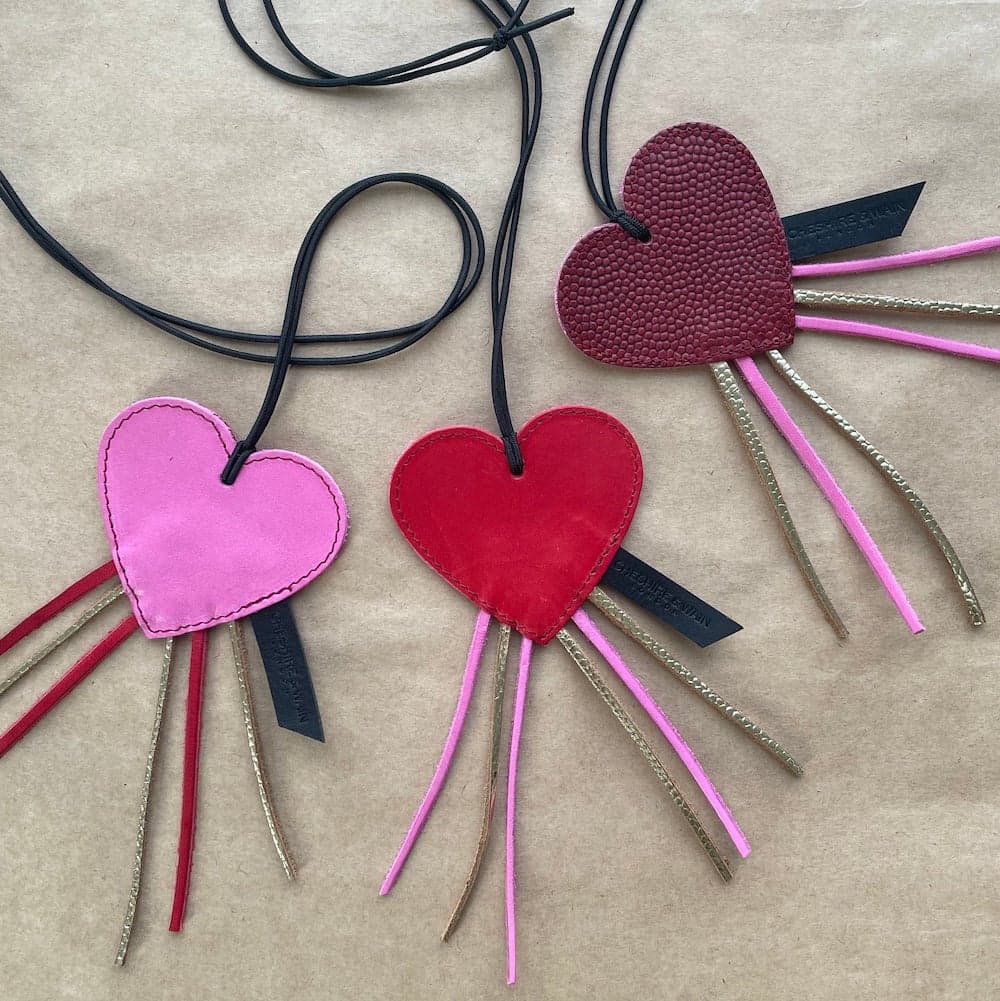 Three pink and red heart shaped leather cat toys